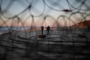 U.S. Customs and Border Protection (CBP) officials walk on the beach in San Diego County, U.S., as photographed through the border wall in Tijuana, Mexico, December 3, 2018 REUTERS/Alkis Konstantinidis
