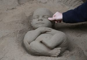 An artist works on a sand sculpture representing baby Jesus as a part of nativity scene in St. Peter's square at the Vatican, December 6, 2018. REUTERS/Alessandro Bianchi