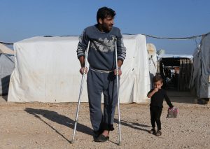 A Syrian refugee walks on crutches at a refugee camp in Akkar, northern Lebanon, November 27, 2018. Picture taken November 27, 2018. REUTERS/Mohamed Azakir