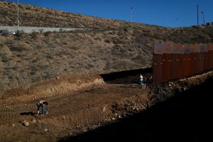 FILE PHOTO: Workers on the U.S. side, paint a line on the ground as they work on the border wall between Mexico and the U.S., as seen from Tijuana, Mexico, December 13, 2018. REUTERS/Carlos Garcia Rawlins