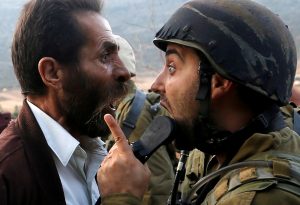 A Palestinian man argues with an Israeli soldier during clashes over an Israeli order to shut down a Palestinian school near Nablus in the occupied West Bank, October 15, 2018. REUTERS/Mohamad Torokman