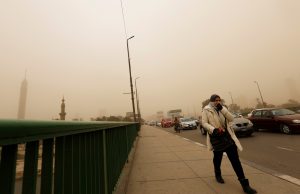 A woman covers her face as she walks on the 6th October Bridge during a sandstorm in Cairo, Egypt January 16, 2019. REUTERS/Amr Abdallah Dalsh