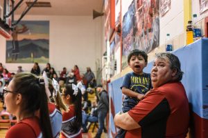 Tracy Lawrence (R), 51, a furloughed Bureau of Indian Affairs worker, holds his grandson while attending a high school basketball game on the Cheyenne River Reservation in Eagle Butte, South Dakota, U.S. January 26, 2019. REUTERS/Stephanie Keith